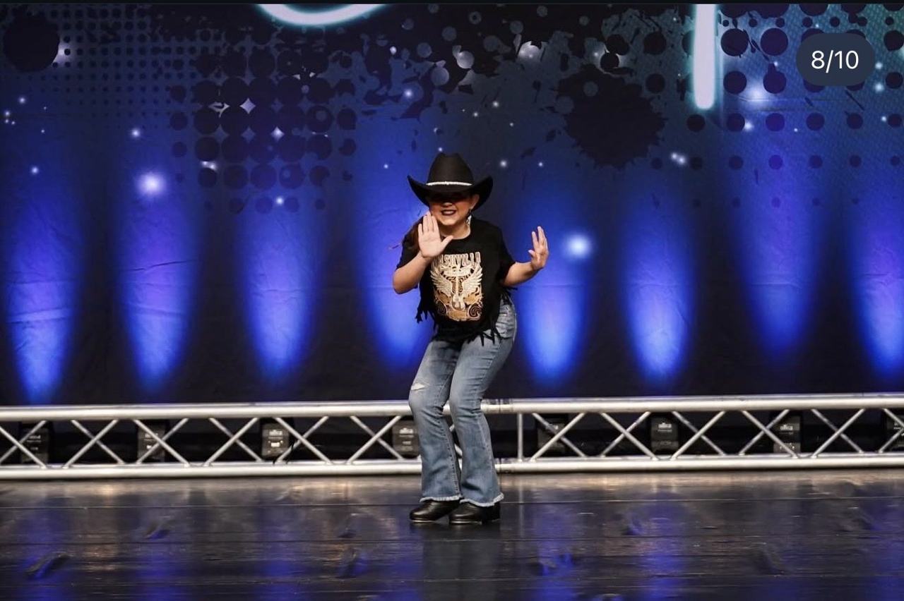 A Mini dancer performing a solo on the competition stage